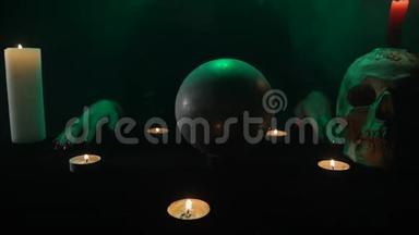 可怕的接近女巫<strong>召唤</strong>水晶球，有蜡烛的桌子和头骨，烟雾